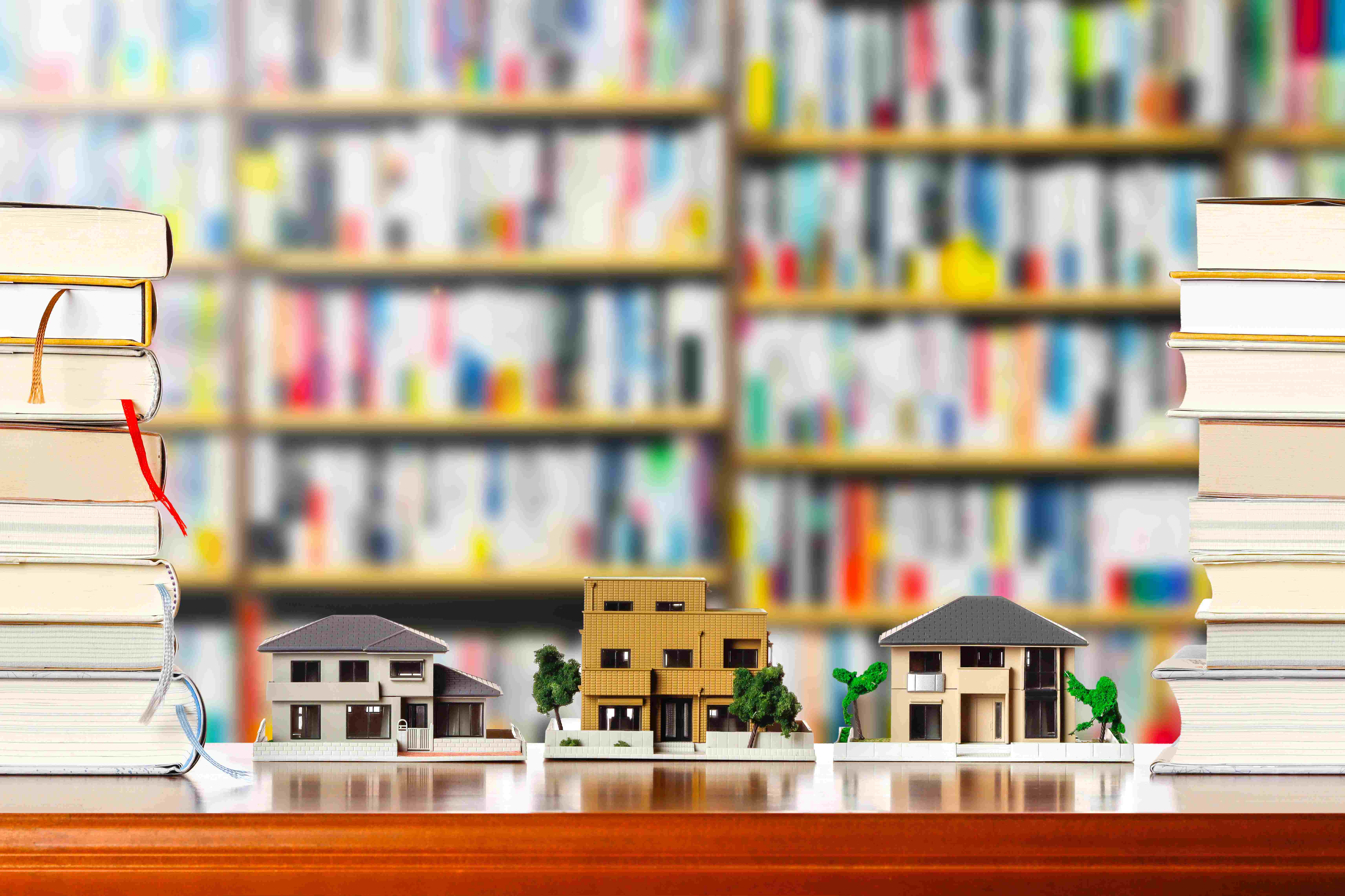 House models and stack of books on the table with blurry background