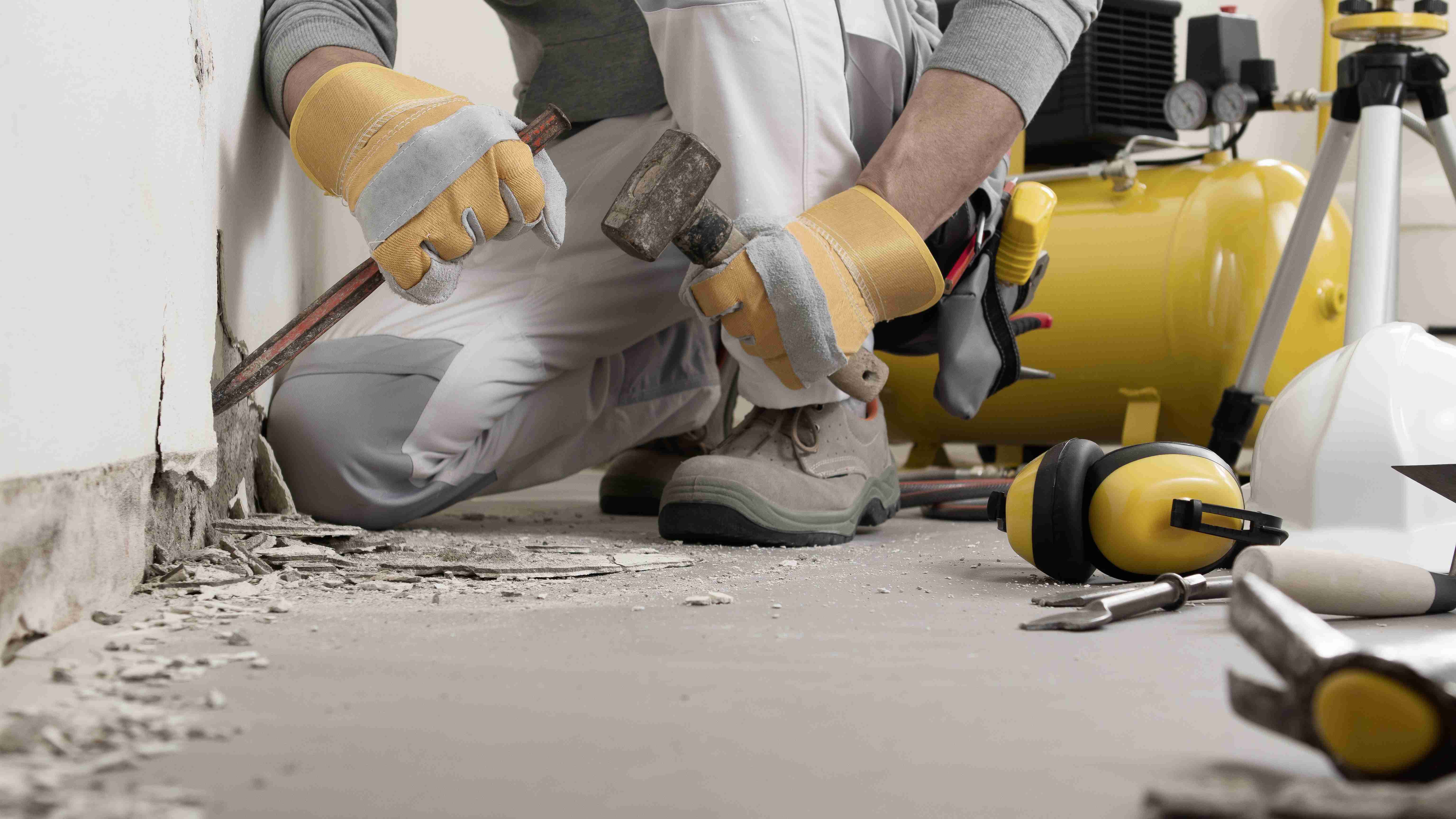 Construction worker working with hammer and chisel