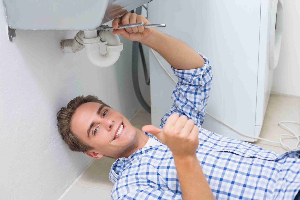 A plumber repairs a leaking faucet in a bathroom